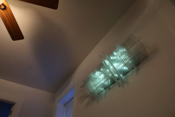Solar Thing, unique solar-powered hand-made pale green four-foot long LED light sculpture by Lumencrafter, mounted sideways high up on dining room wall.