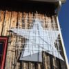 Barn Star, soft white original handmade Lumencrafter LED light sculpture, hanging on the barn at the 2018 Local Colour Art Garden, Flesherton.