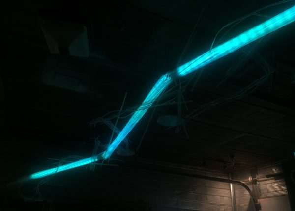 22-foot-long pendant LED light sculpture, changing colours.  LED lights run through three acrylic tubes joined with heavy gauge wire, wrapped with strips of steel mesh and polycarbonate.  stunning; completely original.