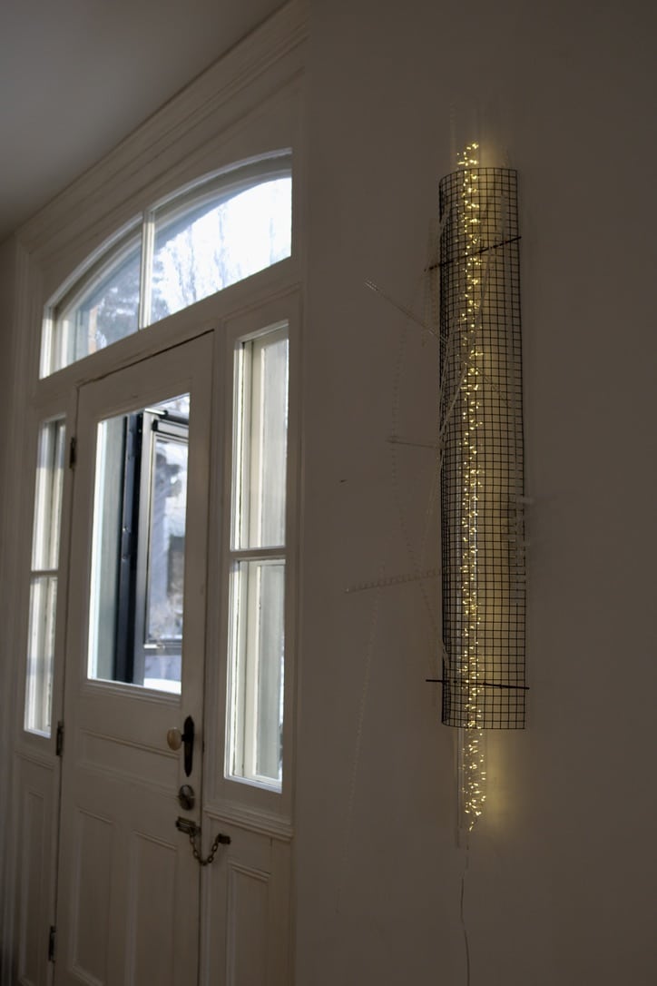 Cascade, original Lumencrafter LED Light Sculpture, wall sconce column of warm white light encased in metal mesh shot through with soft white polycarbonate strips.