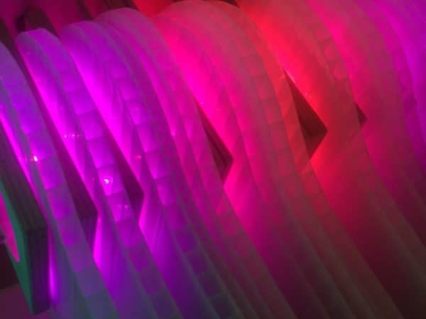 purple-red  layers of vertical polycarbonate, close-up of Weight of Beauty, an LED wall-mounted light sculpture by Lumencrafter.