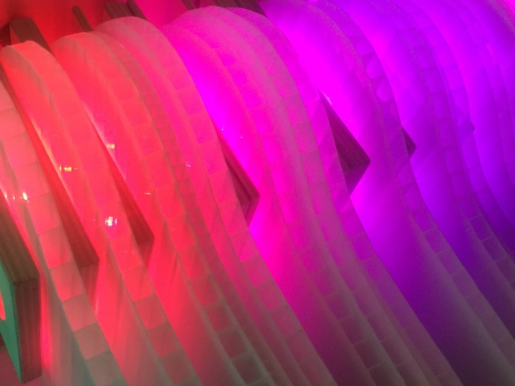 red-purple layers of vertical polycarbonate, close-up of Weight of Beauty, an LED wall-mounted light sculpture by Lumencrafter.