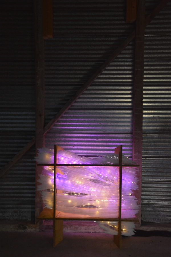 original LED light sculpture, violet-pink and white light, free-standing, slightly more than 2 feet square, glows against corrugated steel
