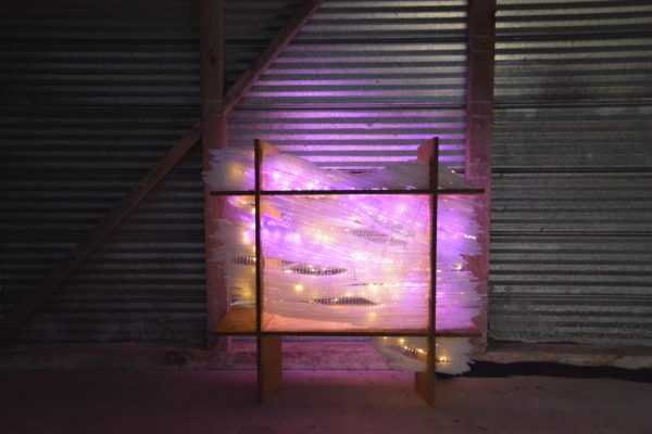 original LED light sculpture, violet-pink and white light, free-standing, slightly more than 2 feet square, glows against corrugated steel