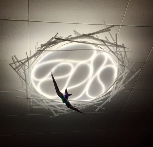 Violet-green Swallow, original LED ceiling light sculpture by Lumencrafter. Back-lit hand-painted bird hanging below a 3-foot diameter diffusion plate, thin polycarbonate strips wound round create bird nest illusion.