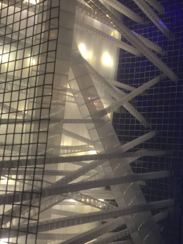 Extreme close-up of Box #1 original Lumencrafter wall sconce light sculpture.  Rectangular white battery-powered LED light sculpture, soft white fairy lights shine behind a diffusion plate framed by a sturdy steel grid with several thin twinwall strips poking through, up and down, back and forth.