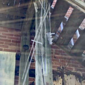 Cascade, original Lumencrafter LED Light Sculpture, wall sconce column of warm white light encased in metal mesh and soft white polycarbonate strips, hung at the 2018 Local Colour Art Garden, Flesherton.