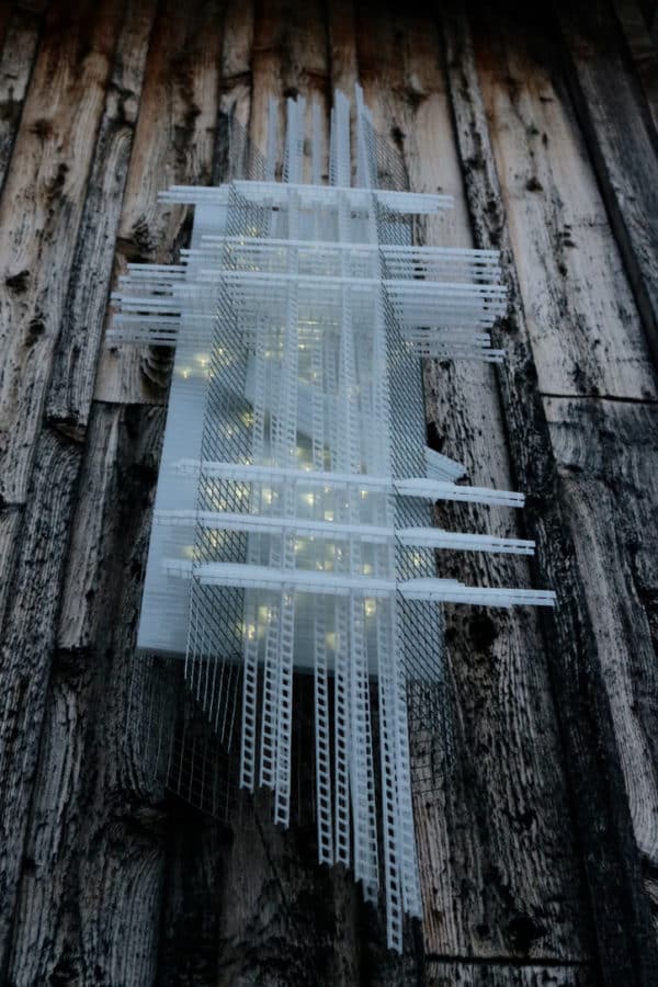 Solar Thing, unique solar-powered hand-made pale green four-foot long LED light sculpture by Lumencrafter mounted on the barn at Flesherton's Local Colour's 2020 Art Garden.