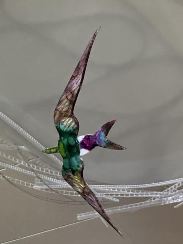 Violet-green Swallow, original LED ceiling light sculpture by Lumencrafter. Close-up of hand-painted bird hanging below a 3-foot diameter diffusion plate, thin polycarbonate strips wound round create bird nest illusion.