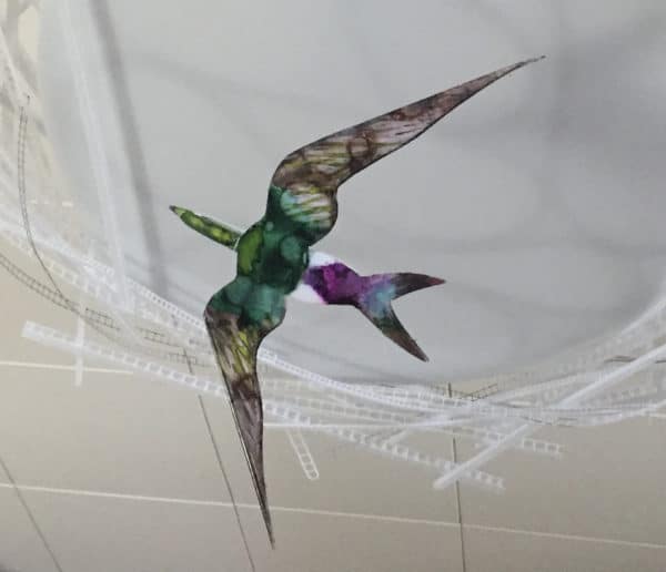 Violet-green Swallow, original LED ceiling light sculpture by Lumencrafter. Close-up of hand-painted bird hanging below a 3-foot diameter diffusion plate, thin polycarbonate strips wound round create bird nest illusion.