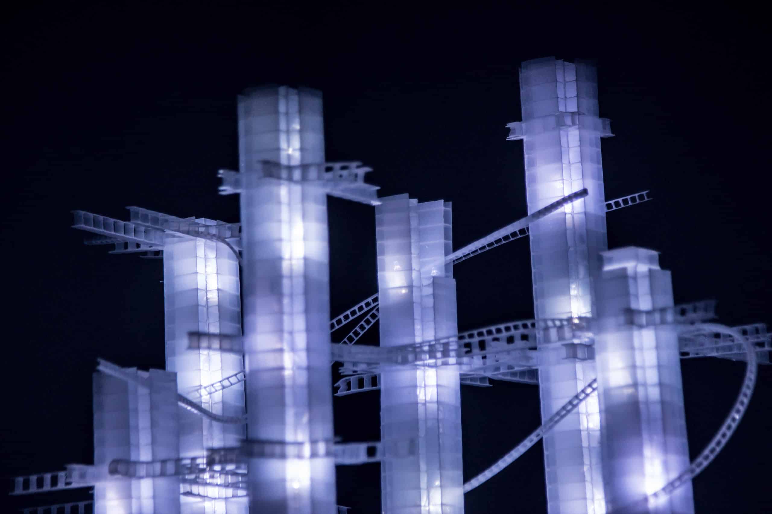 Close-up of tower tops, This Years' Model, a.k.a If You Lived Here, You'd be Home by Now, free-standing soft white original handmade Lumencrafter LED light sculpture, square columns of different heights connected by swirls of laddered polycarbonate twinwall strips, glowing blue-white at Arcadia Art Gallery, Toronto, 2014.