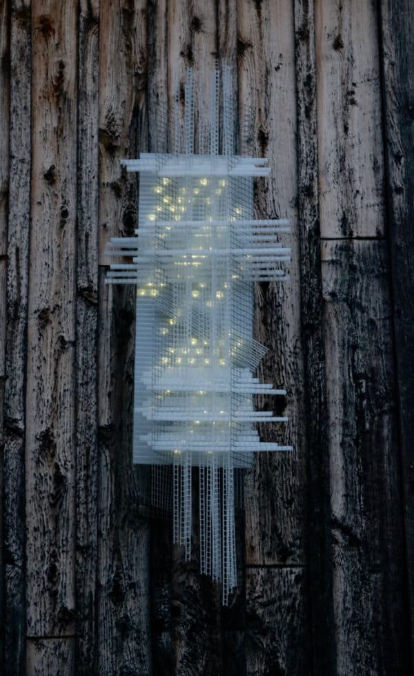 Solar Thing, unique solar-powered hand-made pale green four-foot long LED light sculpture by Lumencrafter mounted on the barn at Flesherton's Local Colour's 2020 Art Garden.